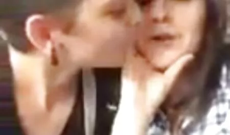 Eine junge Frau, Tochter, Nachbar, in einem blauen Hemd, Jeans und Shorts, und ein reife weiber filme Dutzend mit ihm, während er auf der Couch sitzt.